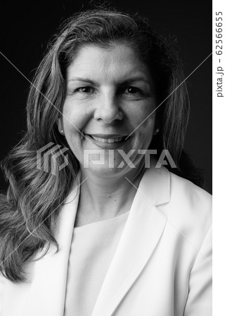 Mature beautiful businesswoman against gray background in black 62566655