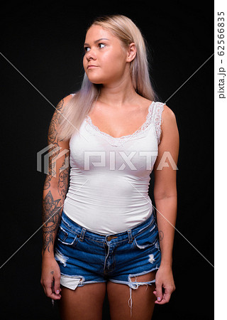 Young beautiful blonde woman against black background Young beautiful blonde woman against black background 62566835