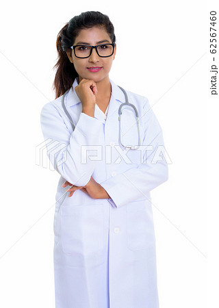Studio shot of young beautiful Persian woman doctor thinking whi Studio shot of young beautiful Persian woman doctor thinking whi 62567460
