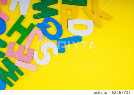 ABC wooden letters alphabet scattered on a yellow ABC wooden letters alphabet scattered on a yellow 62567732