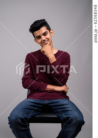 Young Indian man against gray background 62568348