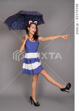 Young beautiful woman against gray background Young beautiful woman against gray background 62570598