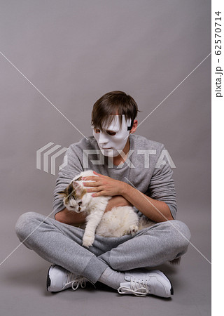 Young handsome man wearing white mask against gray background Young handsome man wearing white mask against gray background 62570714