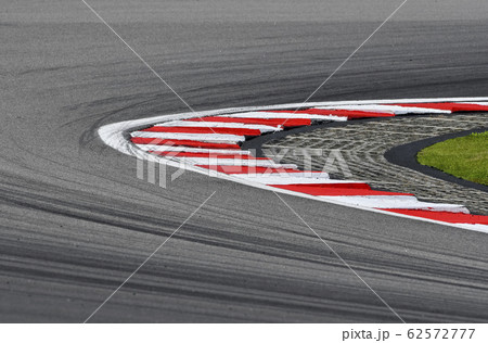 Curving asphalt red and white kerb of a race track 62572777