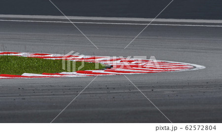 Curving asphalt red and white kerb of a race track Curving asphalt red and white kerb of a race track 62572804