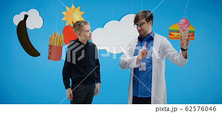 Doctor explaining to boy about healthy and unhealthy food Doctor explaining to boy about healthy and unhealthy food 62576046