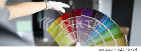 Repairman looking at walls and palette and trying to choose color for interior Repairman looking at walls and palette and trying to choose color for interior 62576724