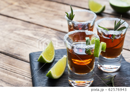 Glass with alcohol, salt and lime on a wooden 62576943