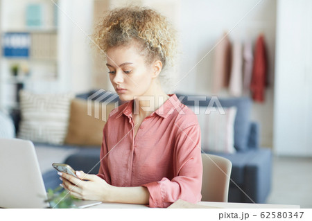 Woman using her phone 62580347