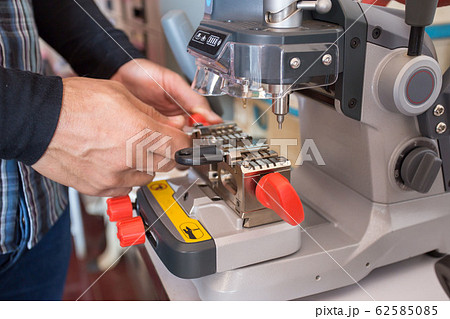 Locksmith in workshop makes new key. Professional Locksmith in workshop makes new key. Professional 62585085