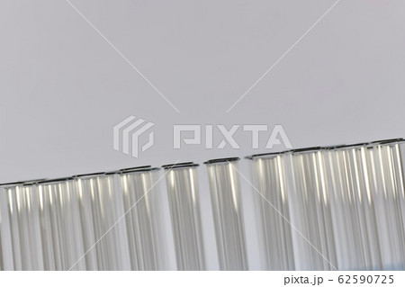 A row of glass test tubes sloping the left-to-right bottom-up line. 62590725