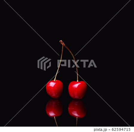 two cherries on black background two cherries on black background 62594715