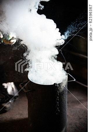 Blacksmith forging - Cooling out an item in the bucket of cool water 62596367
