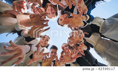 Happy friends connected in a ring together. View from the bottom. The concept of strong friendship. 62599117