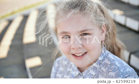 Portrait of a young blonde and smiling teen girl Portrait of a young blonde and smiling teen girl 62599219