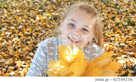 Smiling teen girl posing with autumn leaves. Smiling teen girl posing with autumn leaves. 62599256