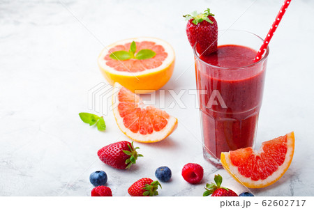Strawberry, pink grapefruit smoothie with acai powder on a grey stone background. Copy space. 62602717