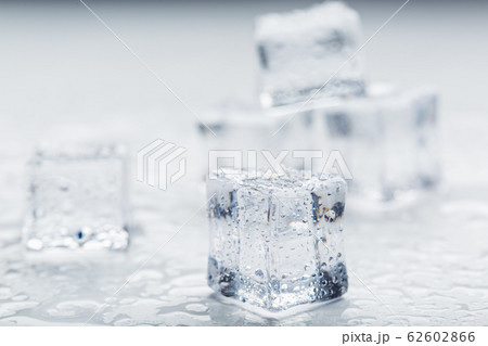 Ice cubes with water drops scattered on a white Ice cubes with water drops scattered on a white 62602866