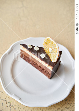 Chocolate sponge cake, with mousse, decorated with Orange slice and meringue. Breakfast in the cafe, morning coffee. on wooden table. 62605094