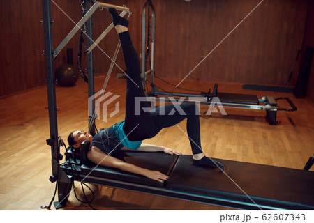Slim woman doing stretching pilates exercise Slim woman doing stretching pilates exercise 62607343