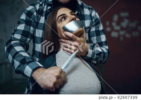 Maniac kidnapper scares his victim with a knife 62607399