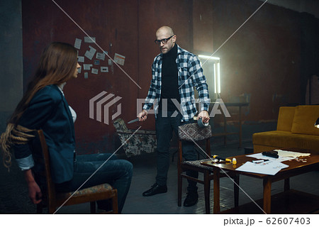 Maniac kidnapper and his victim with taped mouth 62607403