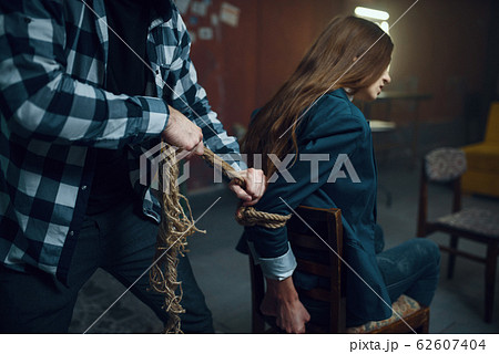 Maniac kidnapper ties his female victim with rope Maniac kidnapper ties his female victim with rope 62607404