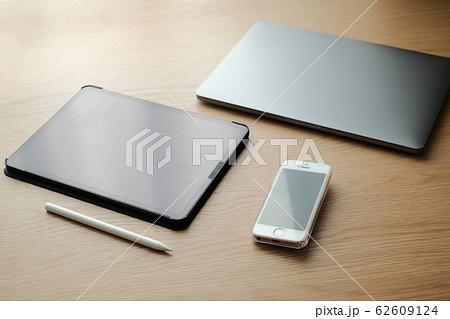 木の机の上のビジネスツールのパソコンとスマホとタブレット端末とタッチペン 俯瞰 62609124