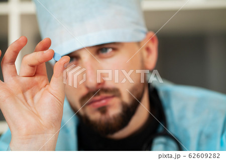 Close up of male doctor holding pill for men health 62609282