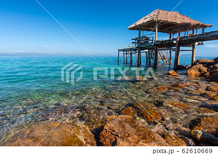 Wooden bridge over crystal clear aqua sea 62610669
