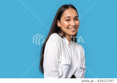 Freestyle. Young woman wearing shirt standing isolated on blue posing to camera smiling playful close-up Freestyle. Young woman wearing shirt standing isolated on blue posing to camera smiling playful close-up 62611597