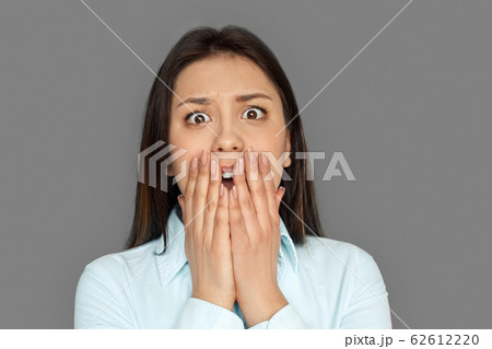 Freestyle. Young woman standing isolated on grey screaming frightened close-up Freestyle. Young woman standing isolated on grey screaming frightened close-up 62612220