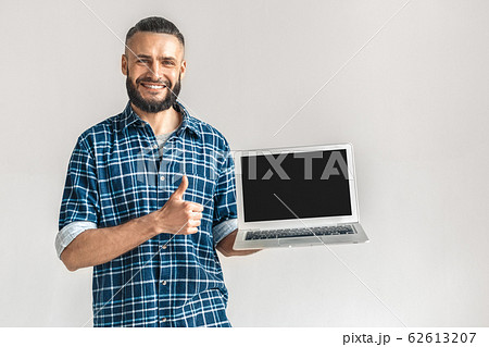 Freestyle. Guy in checkered shirt standing isolated on white showing screen of laptop copy space showing thumb up smiling happy Freestyle. Guy in checkered shirt standing isolated on white showing screen of laptop copy space showing thumb up smiling happy 62613207