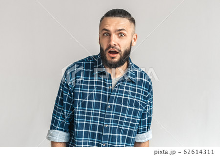 Freestyle. Guy in checkered shirt standing isolated on white looking camera surprised 62614311