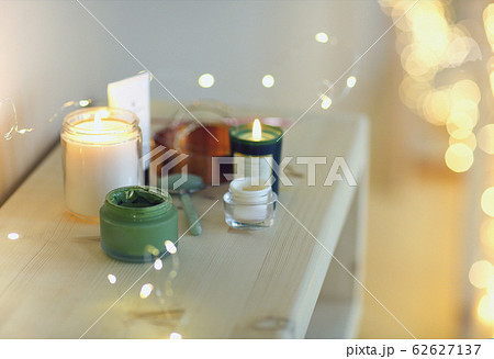 Burning candles and containers with various 62627137