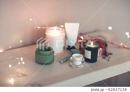 Burning candles and containers with various 62627138