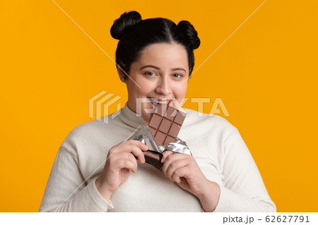 Positive Fatty Girl Biting Chocolate Bar, Enjoying Eating Sweets Positive Fatty Girl Biting Chocolate Bar, Enjoying Eating Sweets 62627791