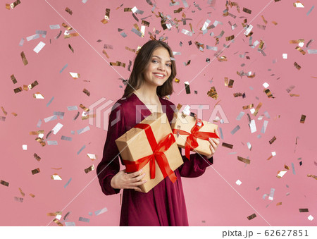 Beautiful Girl Standing Under Falling Confetti With Gift Boxes In Hands Beautiful Girl Standing Under Falling Confetti With Gift Boxes In Hands 62627851