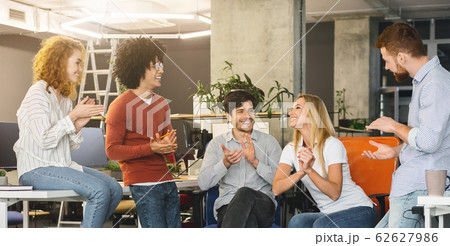 Young creative team cheering new comer girl in office Young creative team cheering new comer girl in office 62627986