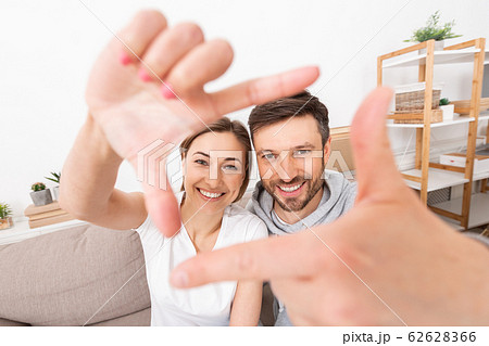 Overjoyed couple taking selfie with hand frame gesture Overjoyed couple taking selfie with hand frame gesture 62628366
