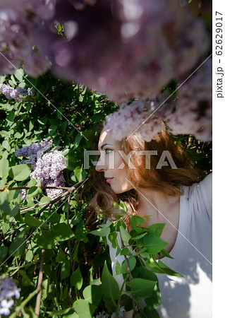 Girl with red hair in the park with trees in bloom. Girl with red hair in the park with trees in bloom. 62629017