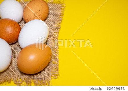 White and brown Easter eggs bright yellow background. Concept happy Easter. White and brown Easter eggs bright yellow background. Concept happy Easter. 62629938