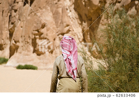bedouin in white goes in the canyon in the desert 62633406