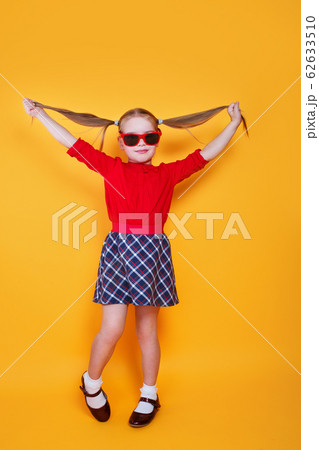 Cute little girl in sunglasses rejoices spreading her arms to the sides. Cute little girl in sunglasses rejoices spreading her arms to the sides. 62633510