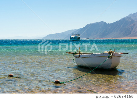 old wooden fishing boat in the sea against the backdrop of the high rocky mountains in Egypt Dahab old wooden fishing boat in the sea against the backdrop of the high rocky mountains in Egypt Dahab 62634166