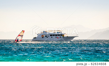 big boat and a surfer in the sea on the background of a rocky coast in Egypt Dahab big boat and a surfer in the sea on the background of a rocky coast in Egypt Dahab 62634608