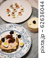 A rusk with cheese, turkey breast, quail egg, sun-dried tomato and valerianella locusta 62636044