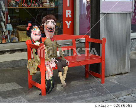 Puppet couple imitating a married couple sitting on a bench in the street Puppet couple imitating a married couple sitting on a bench in the street 62636065
