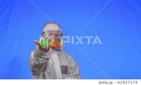 Doctor in respirator show a virus model. Slow motion. Woman wearing protect medical aerosol spray paint mask. Green ball spike thorn. Doctor in respirator show a virus model. Slow motion. Woman wearing protect medical aerosol spray paint mask. Green ball spike thorn. 62637174