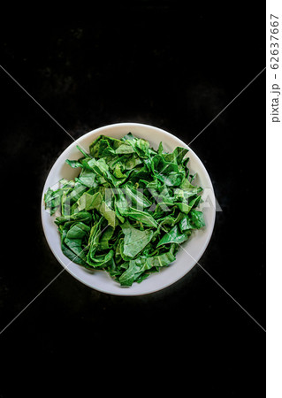 A bunch of young fresh juicy green spinach on a rustic wooden old-time red background. Flat lay 62637667